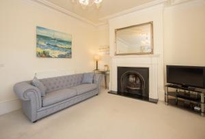 a living room with a couch and a fireplace at Beautiful Victorian Coastal Holiday Home in Kent