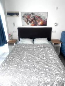 1 dormitorio con 1 cama con edredón gris en Relax apartamento 5, en Las Palmas de Gran Canaria