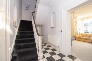 a stairway with a black and white checkered floor at Beautiful Victorian Coastal Holiday Home in Kent