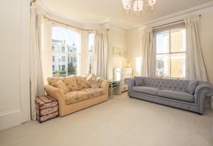 a living room with a couch and a couch and windows at Beautiful Victorian Coastal Holiday Home in Kent +27 photos