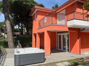an orange house with a bath tub in front of it at Principesse in Rosolina Mare