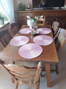 a wooden table with pink plates on top of it at Mieszkanie Mickiewicza ... 45 in Sandomierz