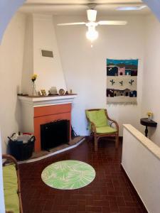 a living room with a fireplace and a green chair at Casa David in Castelo de Vide
