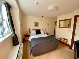 a bedroom with a bed and a large window at The Globe Inn in Kingsbridge