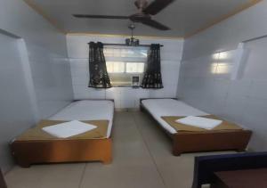 Duas camas num pequeno quarto com uma janela em Hotel Rupali em Mumbai