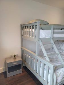 a bedroom with two bunk beds and a table at Brand new apartment 20 mins from London Waterloo BP34 in London