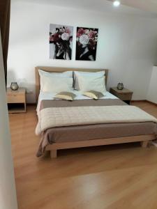 uma cama num quarto com duas fotografias na parede em mezzanino Ribeira Brava na Vila da Ribeira Brava