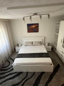 een slaapkamer met een groot wit bed in een kamer bij Guesthouse Mema in Sarajevo