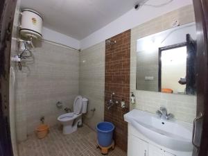 ein Badezimmer mit einem WC, einem Waschbecken und einem Spiegel in der Unterkunft Hotel Cottage Orchid Nainital - Parking Facilities - Luxury & Hygiene Room - Best Seller in Nainital