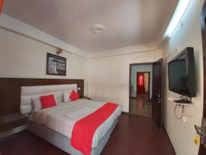 a bedroom with a bed and a flat screen tv at Hotel Cottage Orchid Nainital - Parking Facilities - Luxury & Hygiene Room - Best Seller in Nainital