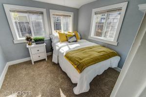 a bedroom with a bed and two windows at *H* NEW! Downtown Cottage Newly Renovated! * in Colorado Springs