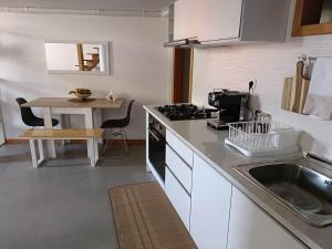 uma cozinha com um lavatório e uma mesa com um fogão em mezzanino Ribeira Brava na Vila da Ribeira Brava