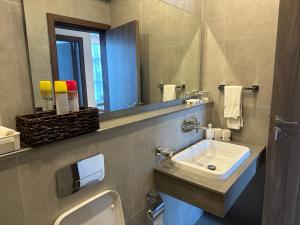 a bathroom with a sink and a mirror at Skynest Residences, 10th floor, Room 1017. in Nairobi +10 photos