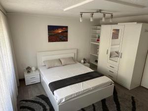 sypialnia z białym łóżkiem i szafą w obiekcie Guesthouse Mema w Sarajewie