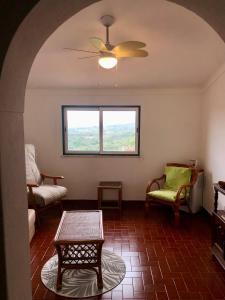 a living room with a ceiling fan and a table at Casa David in Castelo de Vide