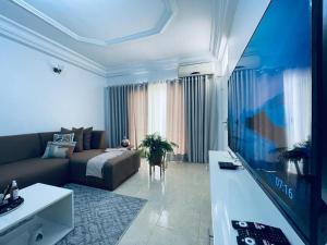 a living room with a couch and a flat screen tv at ESPACE VIRAGE 2 in Dakar