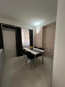 a room with a table and chairs and a brick wall at Reina Apartments Skopje 3 in Skopje