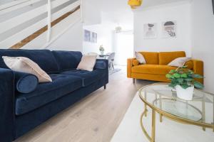 a living room with a blue couch and a glass table at Luxurious 2-Bed House in Dartford in Dartford