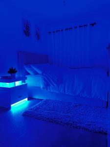 um quarto escuro com uma cama com uma luz azul em Luxurious 2-Bed House in Dartford em Dartford