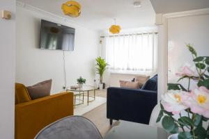 a living room with a blue couch and a table at Luxurious 2-Bed House in Dartford in Dartford