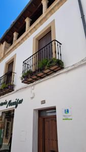 a white building with two balconies and a door at VTAR San Francisco 2º in Baeza