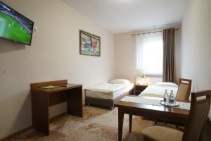 Habitación de hotel con 2 camas y TV en Hotel Alexandra en Olesno