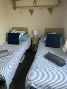 two beds sitting next to each other in a room at The Hideaway Cabin in Seasalter