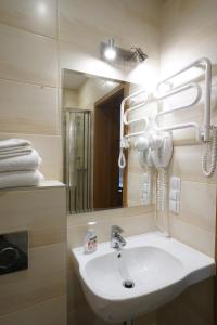 y baño con lavabo blanco y espejo. en Hotel Alexandra en Olesno