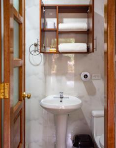 a bathroom with a sink and a toilet and towels at Casa SAMAY OLLANTAYTAMBO in Ollantaytambo