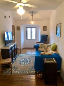 a living room with a blue couch and a tv at Casa David in Castelo de Vide