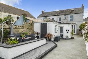 einen Innenhof eines Hauses mit einer Terrasse in der Unterkunft Waters Edge Holiday Home in Hayle, West Cornwall in Hayle