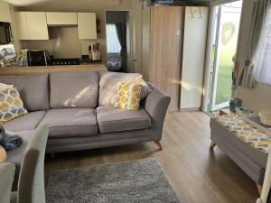 The Hideaway Cabin في Seasalter: غرفة معيشة مع أريكة ومطبخ