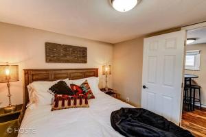 ein Schlafzimmer mit einem weißen Bett mit Kissen darauf in der Unterkunft Manitou Springs Downtown Escape in Manitou Springs