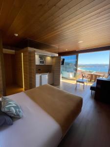 um quarto com uma cama grande e vista para o oceano em Cabañas Fisterra em Fisterra