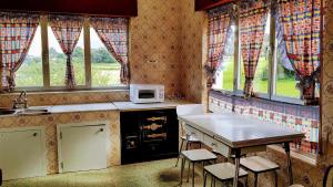 cocina con microondas y mesa con sillas en Casa Vacacional las Tercias, en Niembro