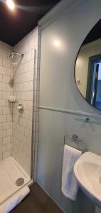 a bathroom with a shower and a sink and a mirror at The Lemon Leaf Café Bar and Townhouse in Kinsale