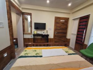 a bedroom with a bed and a television in it at Date Palm Home Stay in Tezpur
