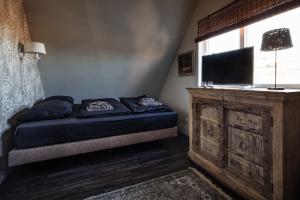 a bedroom with a bed with a tv and a window at Bed and Relax Terschelling in Midsland