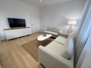 a living room with a couch and a tv at Stadtjuwel: Zentral & Modern in Lichtenfels