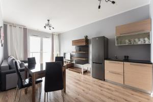 a living room with a dining room table and a kitchen at Apartament Sucha 77 in Gdańsk