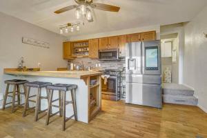 a kitchen with a refrigerator and some bar stools at Charming Victorian Haven Near Garden of the Gods in Colorado Springs