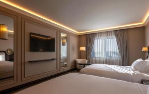 a hotel room with two beds and a flat screen tv at GoldenEye Hotel & Casino in Svilengrad