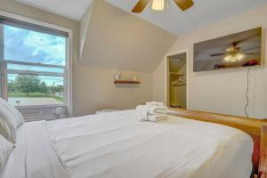 um quarto com uma grande cama branca e uma janela em Charming Victorian Haven Near Garden of the Gods em Colorado Springs