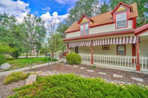 a house with a white fence in front of a yard at Charming Victorian Haven Near Garden of the Gods in Colorado Springs
