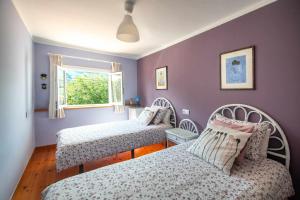 a bedroom with two beds and a window at Villa Selina Llanes – Terraza, Vista y Playa Cerca in La Pereda de Llanes