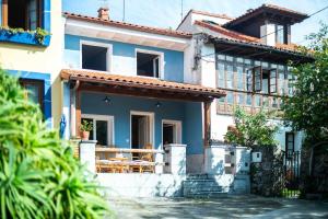 a blue and white house with a porch at Villa Selina Llanes – Terraza, Vista y Playa Cerca in La Pereda de Llanes