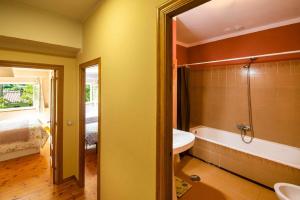 a bathroom with a tub and a sink and a bath tub at Villa Selina Llanes – Terraza, Vista y Playa Cerca in La Pereda de Llanes +26 photos