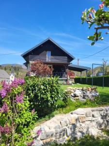 a house with a garden and some flowers at Holiday Home NA VASI in Gorenja Vas