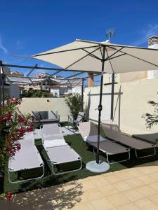a group of lounge chairs under an umbrella at Panoramic Seaview in Mijas
