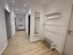 a hallway with white walls and wooden floors and a staircase at Stadtjuwel: Zentral & Modern in Lichtenfels